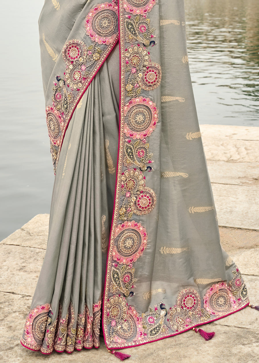 Grey banarasi handloom saree for wedding guest look with pink embroidered blouse, cut work border and tissue silk fabric finish.