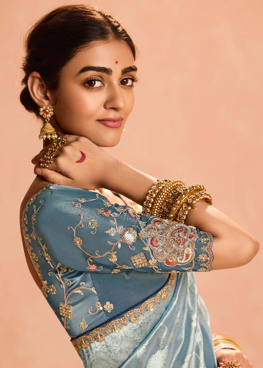 Sophisticated pastel blue banarasi tissue silk saree with intricate embroidery and grey blouse contrast colour combination.