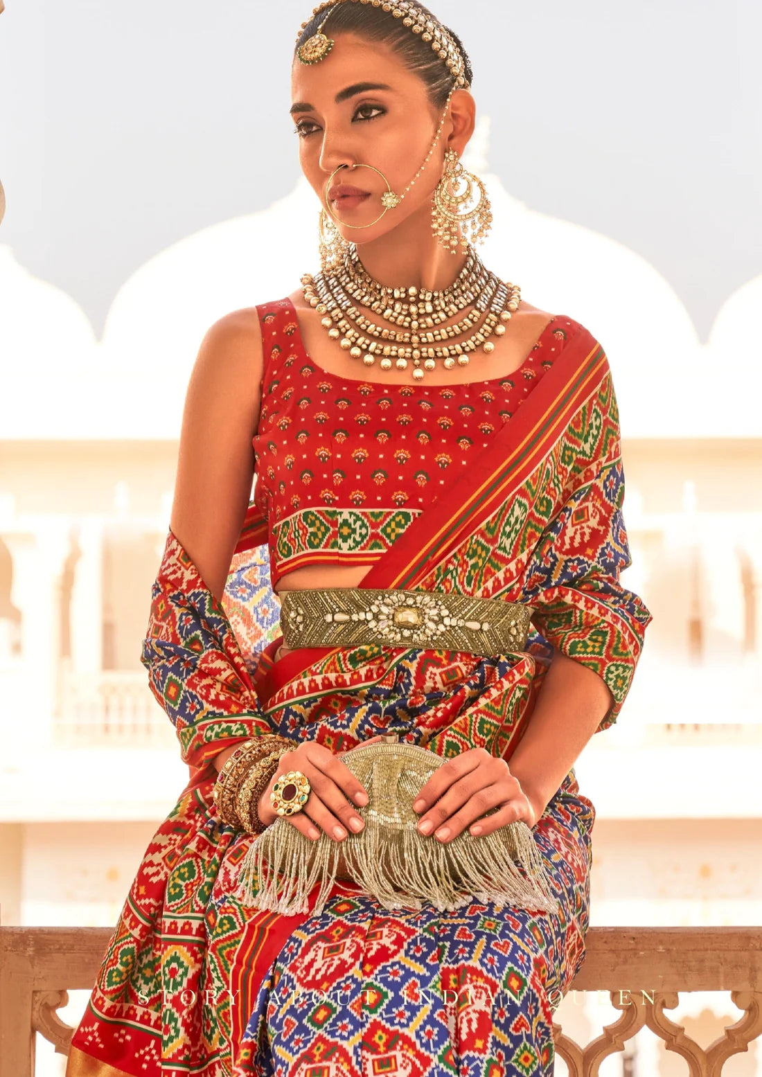 Bride in blue patola saree with red blouse.