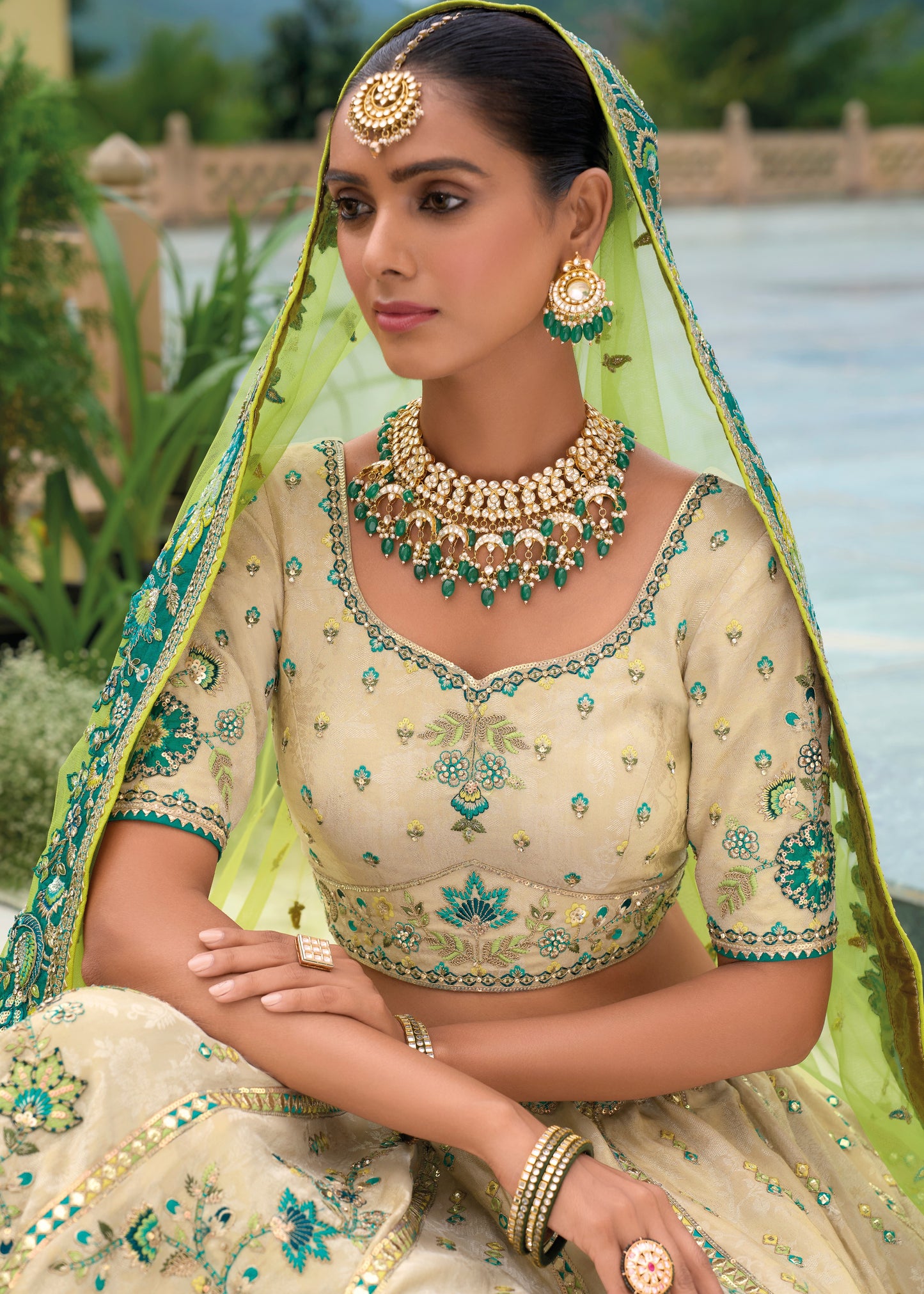 Elegant cream and green silk lehenga choli, designed with delicate peacock embroidery, ideal for wedding and bridal wear events in London UK.