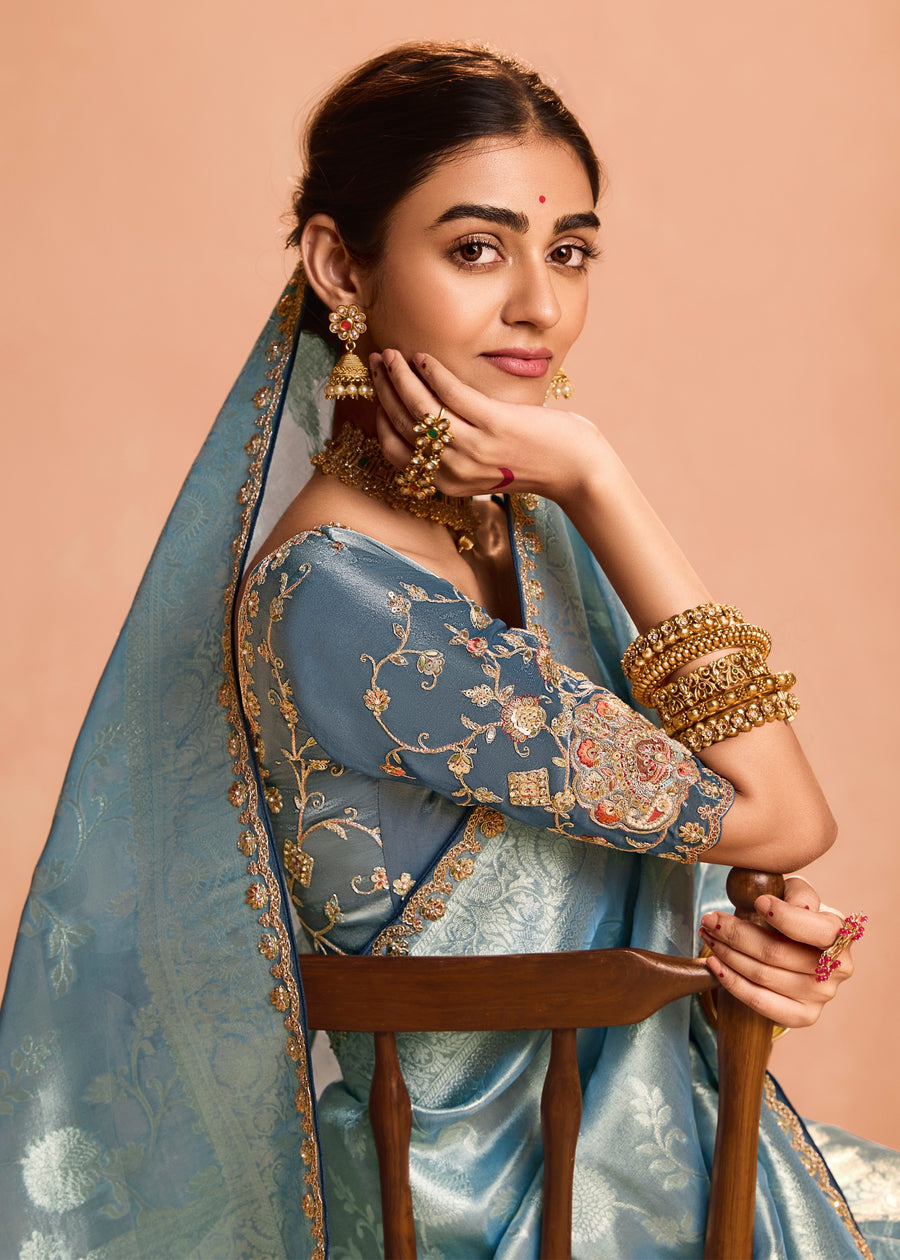 Designer pastel blue handloom banarasi tissue silk saree with contrasting grey blouse featuring embroidery work.