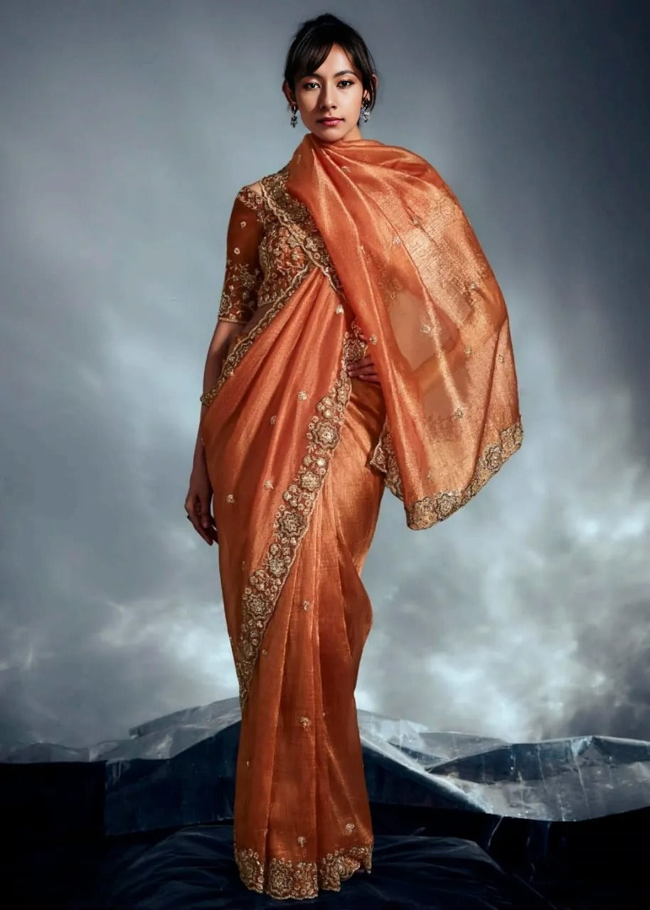 Designer rust orange hand embroidered saree on tissue silk fabric for party wear.