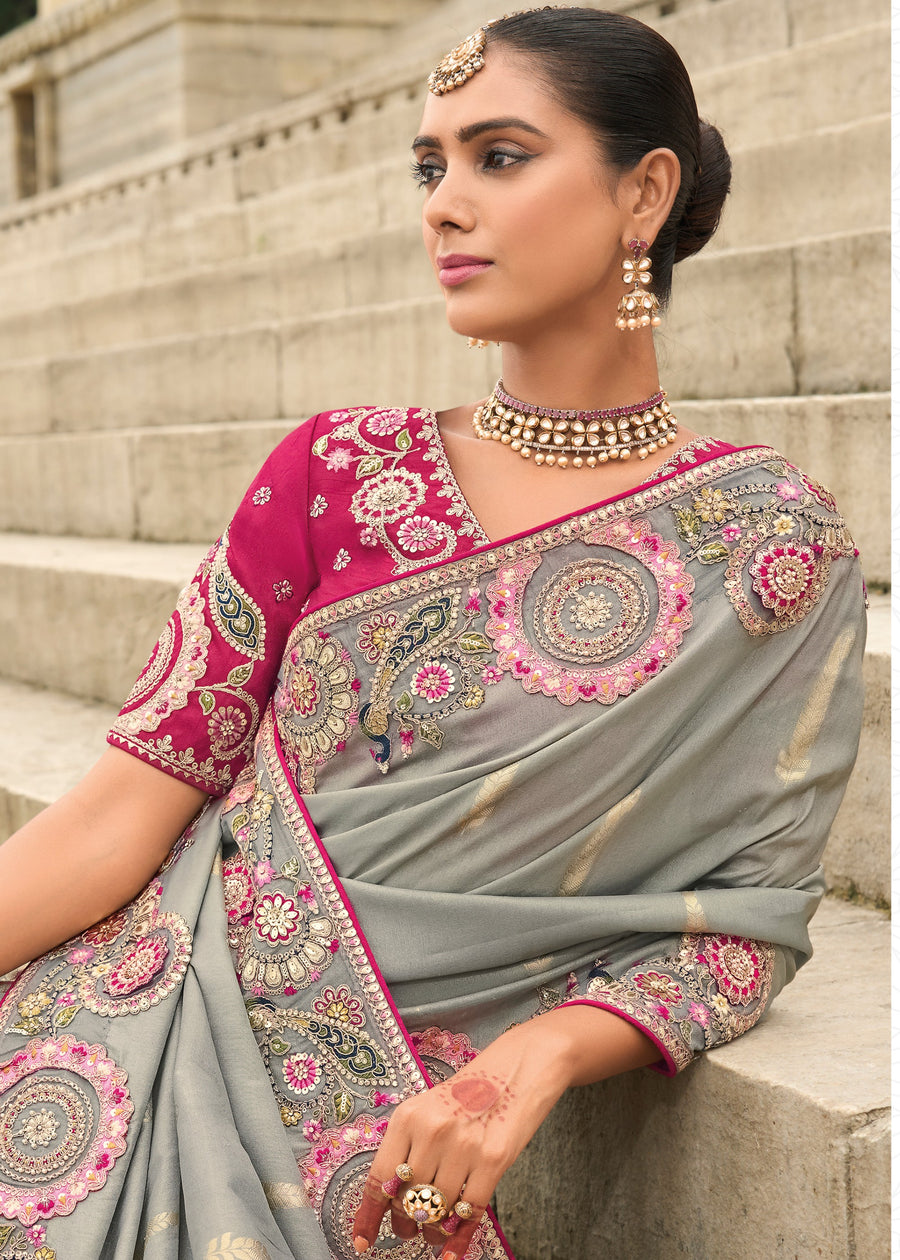 Luxury banarasi viscose tissue silk embroidered saree in grey with artisan cutwork edging and bright rani pink blouse design.