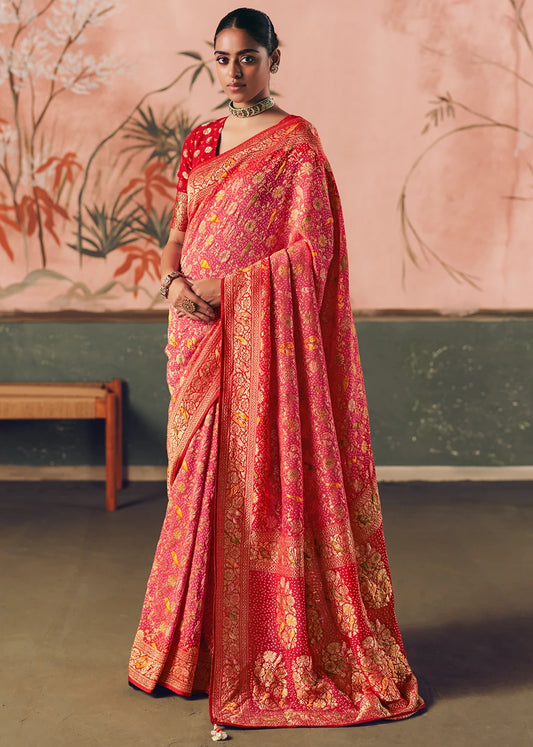 Woman wearing a traditional pastel pink bandhani saree made in pure khaddi banarasi georgette, featuring meenakari floral, birds and animal motifs.