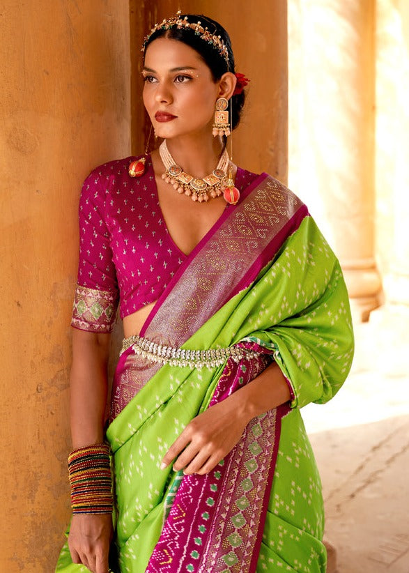 Lawn green colour patola saree online shopping with contrast pink blouse featuring traditional design.