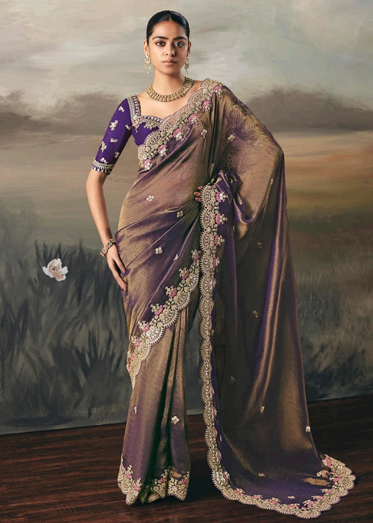 Metallic copper brown bridal saree with hand embroidered design on tissue silk paired with violet purple blouse.