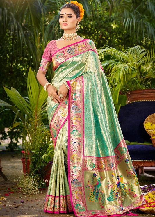Ocean green pure silk Paithani saree in usa draped with pleats showing mor-popat zari border with alternating peacock and parrot motifs, rich pallu with large peacock buttas in gold and silver zari with multicolor meena work, plain ocean green body with self zari checks, contrasting pink blouse piece, Maharashtrian handloom wedding saree.