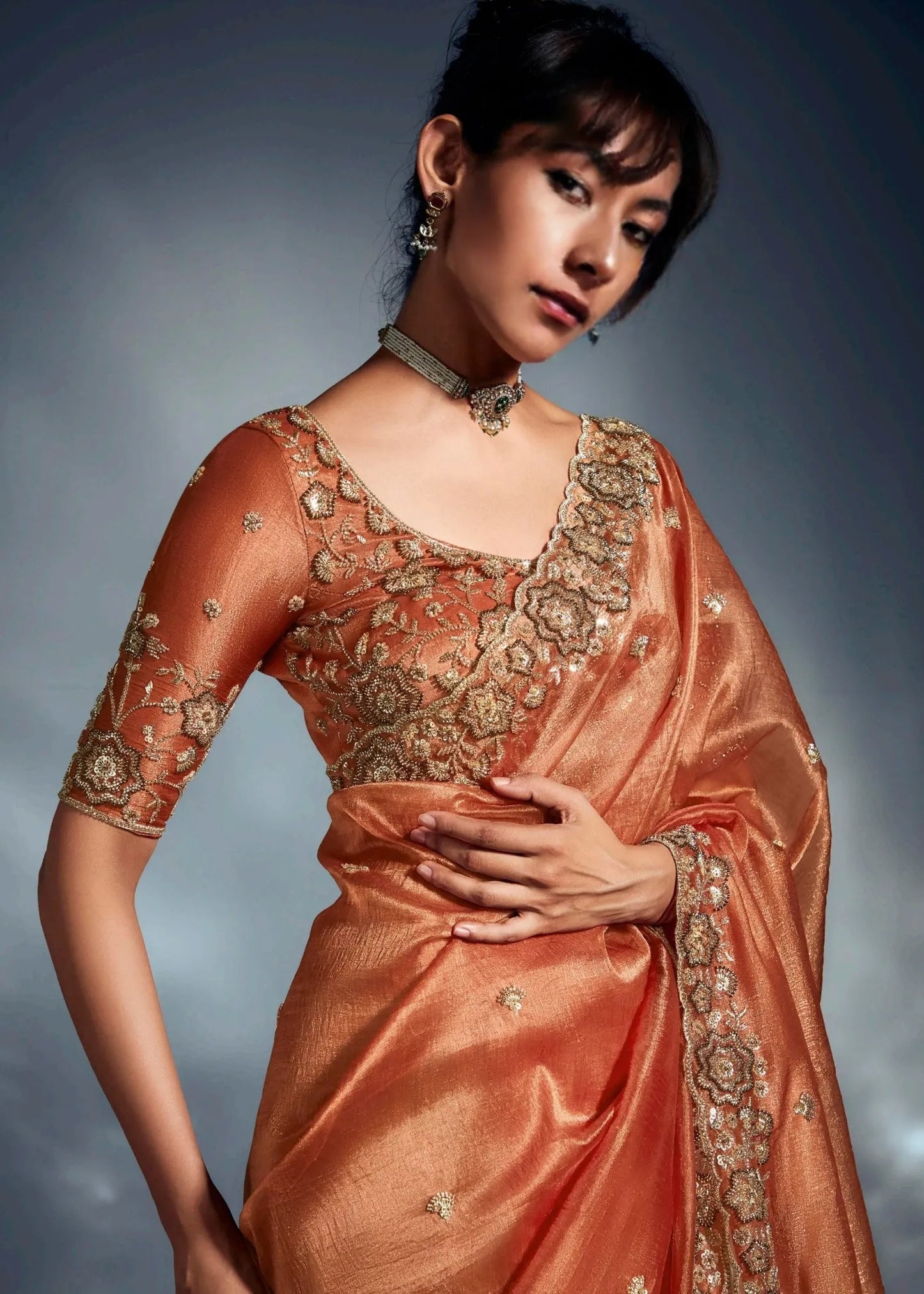 Elegant rust orange tissue silk embroidered saree with blouse piece for reception look.
