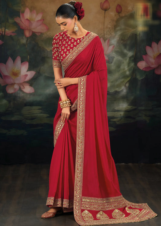 Woman in a red muga silk saree with gold embroidery and traditional jewellery against a lotus flower background.