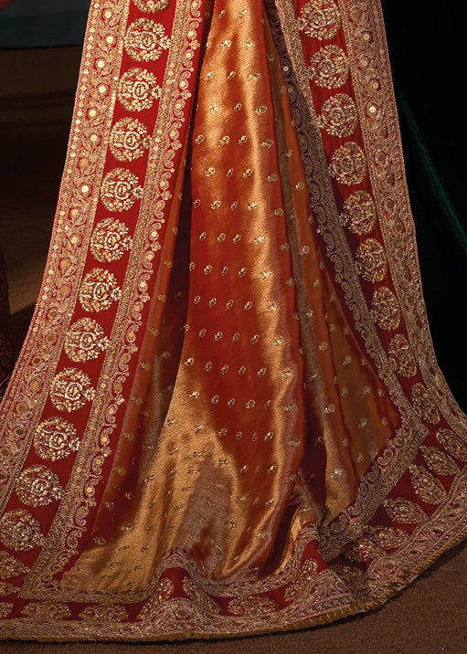 Detailed close-up of the grand, rust orange kanjivaram silk saree pallu featuring gold zari embroidery and shimmering sequin work arranged in traditional motifs.