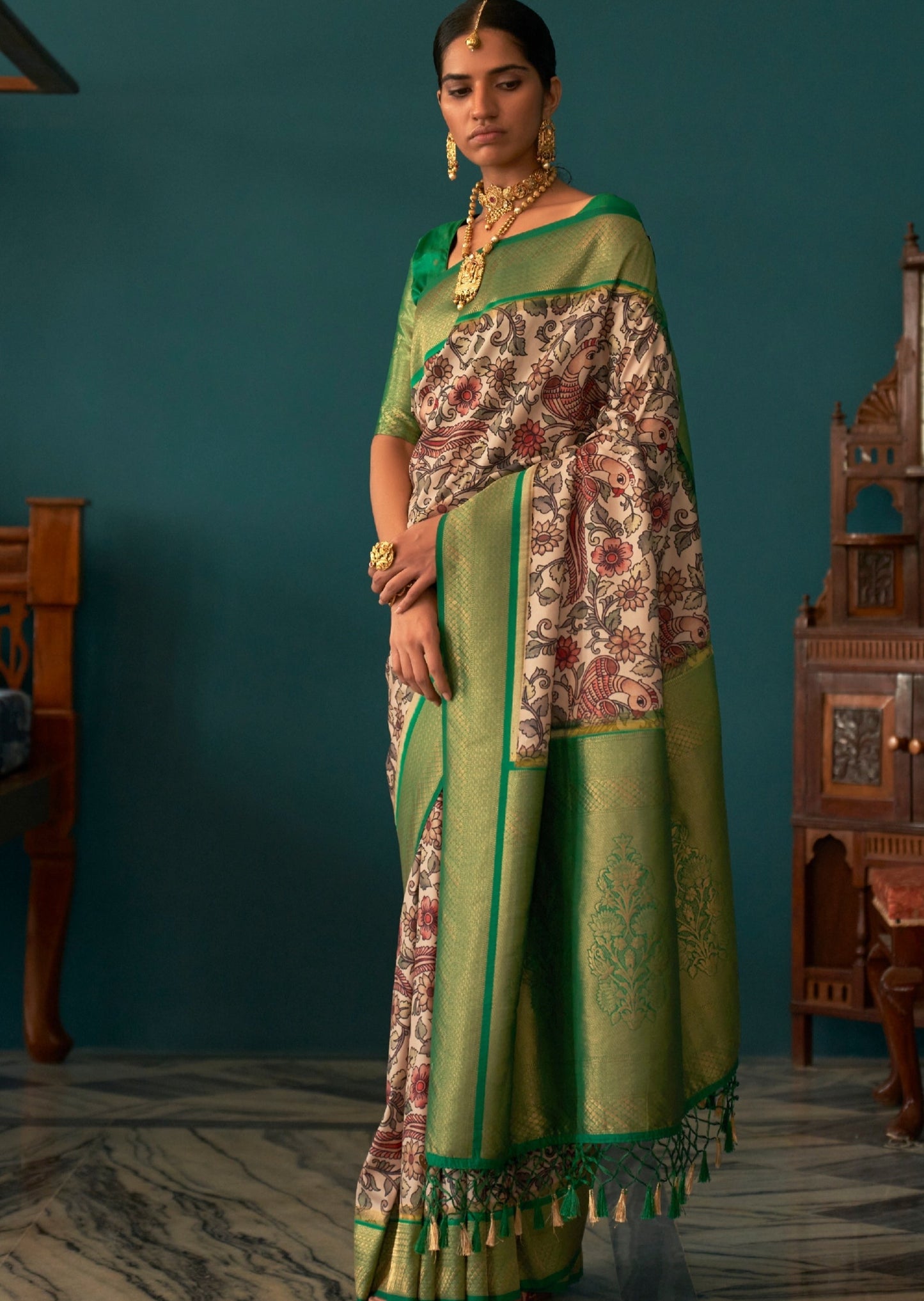 Woman in white color kalamkari saree with banarasi border & contrast green blouse.