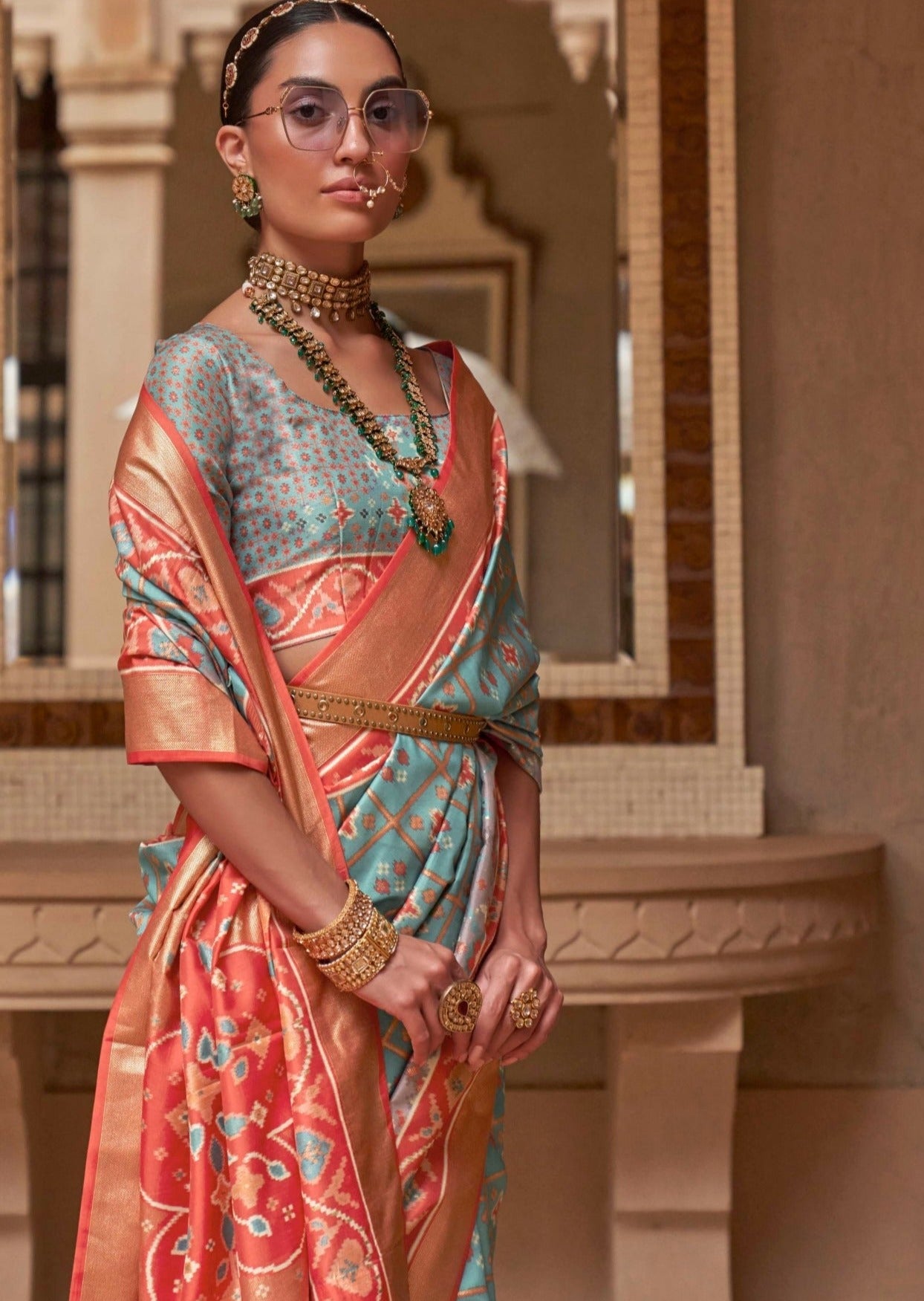 Woman wearing light blue double ikkat patola saree with orange border