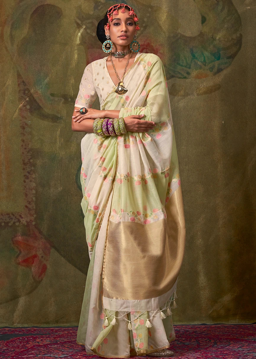 A woman modeling a white and green handwoven cotton silk saree with floral border details and fall pico stitching service.