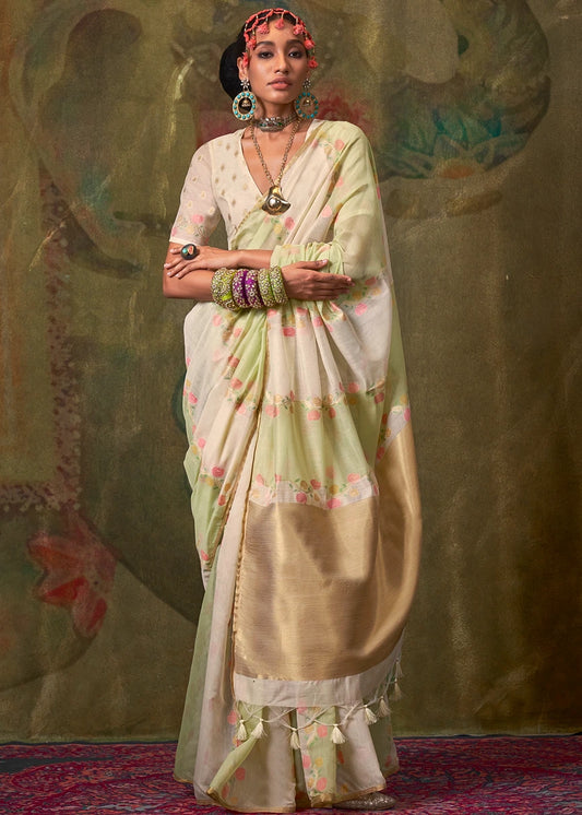 A woman modeling a white and green handwoven cotton silk saree with floral border details and fall pico stitching service.