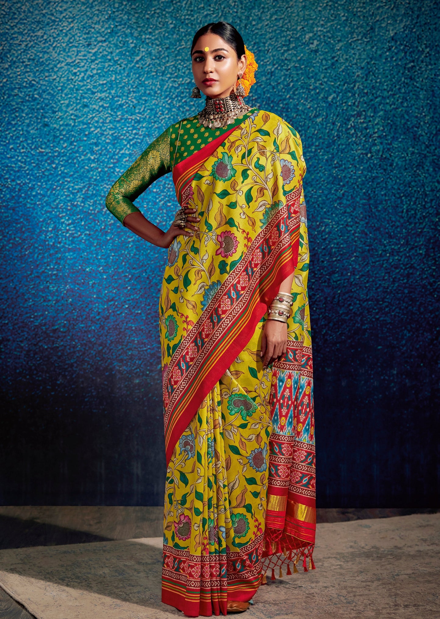 woman standing in Kalamkari Patola Fusion Yellow Saree and Green blouse wearing oxidised jewellery