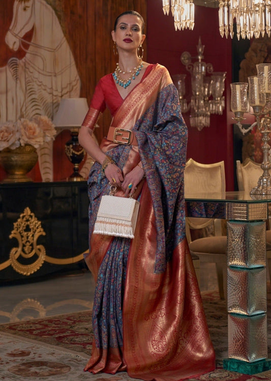 Woman standing in royal blue kashmiri saree with red gold zari banarasi border pallu.