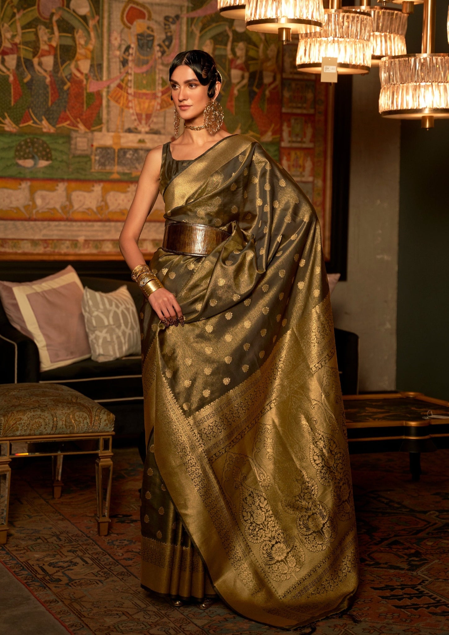 woman standing in Black banarasi silk saree with golden border pallu and butti designs on pleats