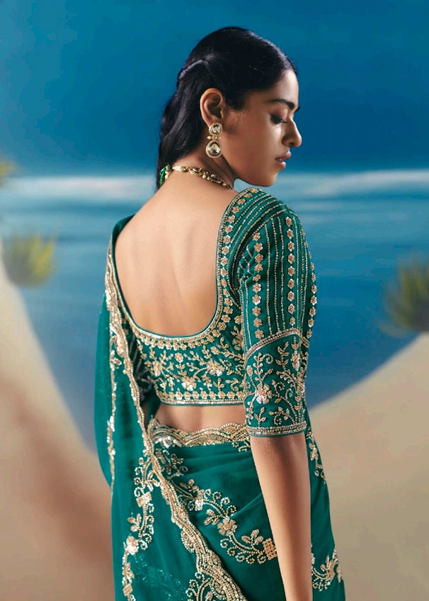 Lightweight emerald green tissue silk wedding saree for bride featuring blouse back design with heavy beadwork embroidery.