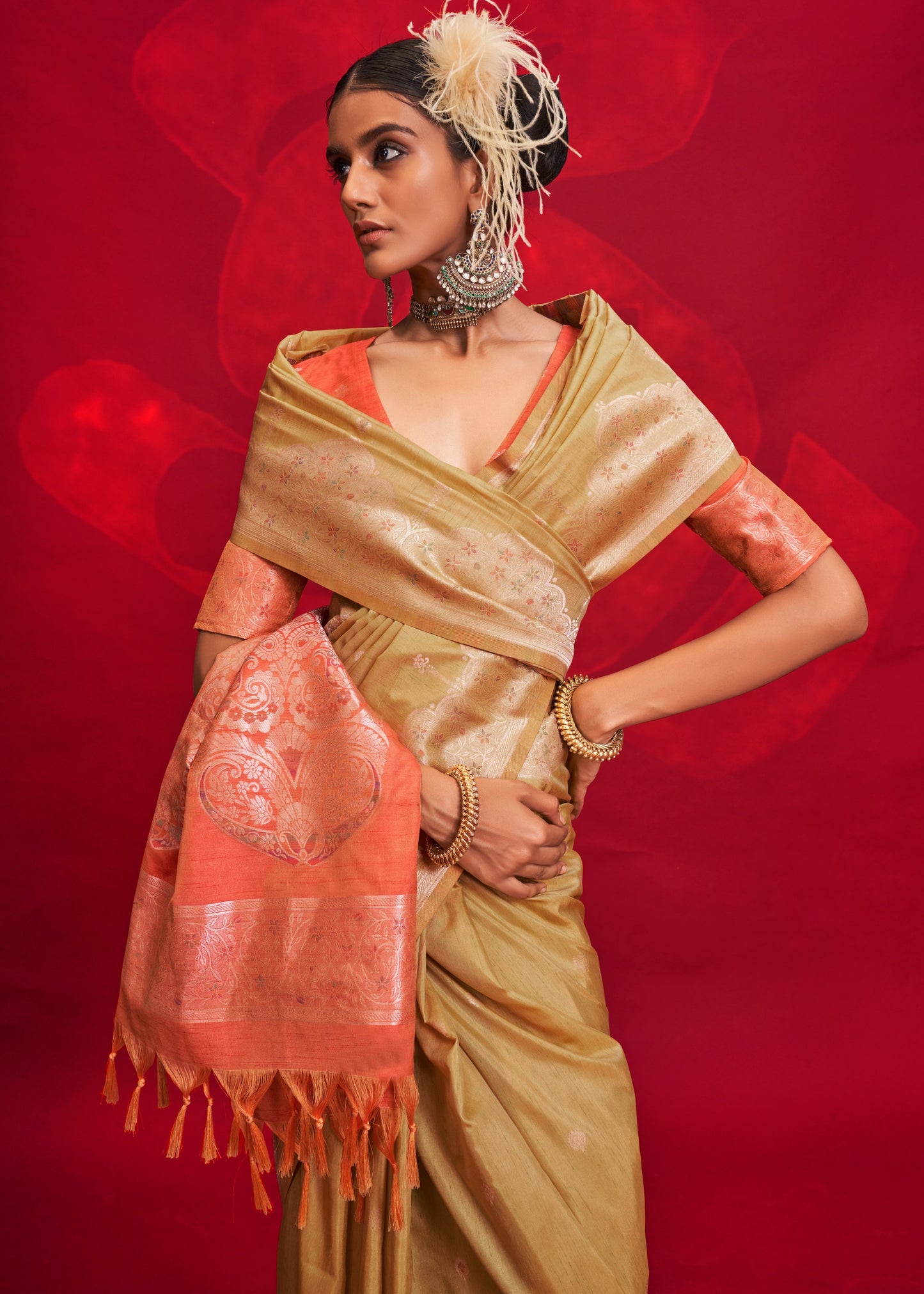 Beige tussar silk designer saree with intricate handloom weaving paired with contrast orange blouse.