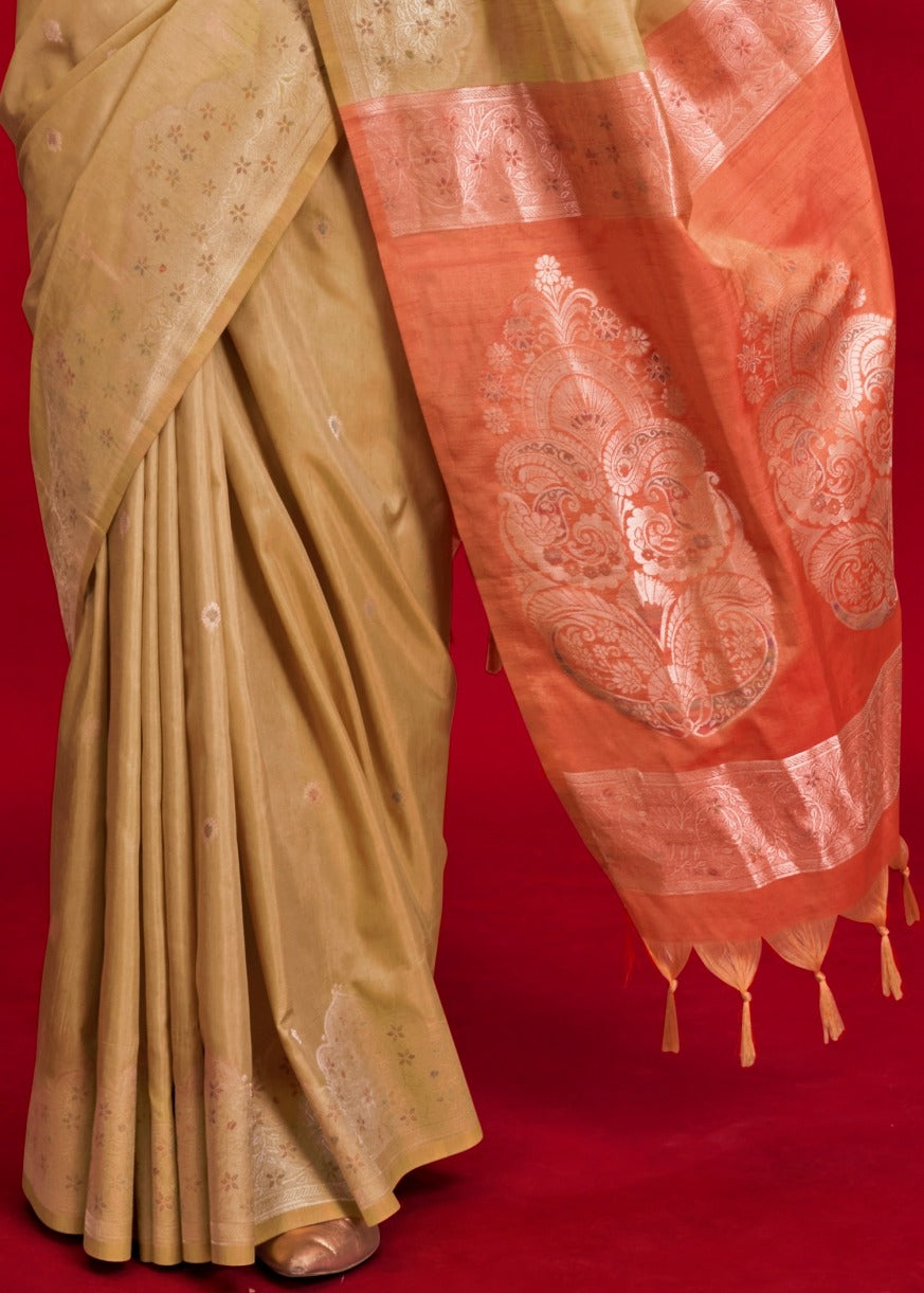 Beige tussar silk saree draped with orange pallu design handwoven with gold zari threads.