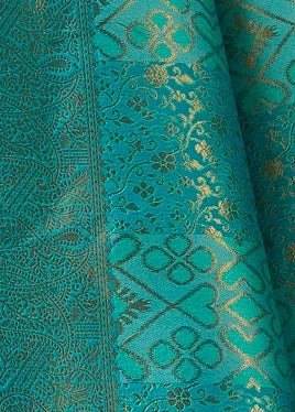 Close-up of blue kanjivaram silk saree design with intricate gold woven floral and geometric patterns.