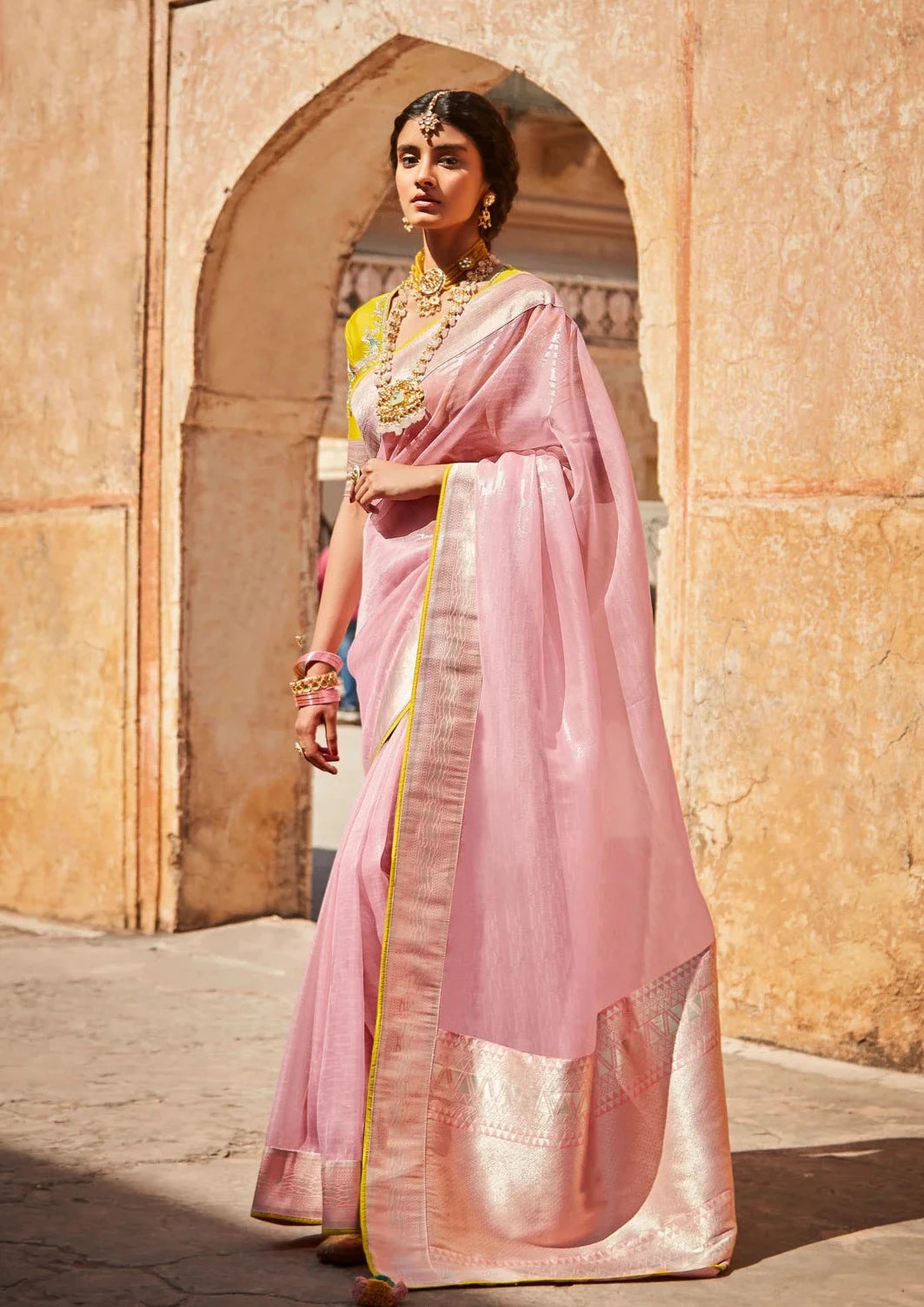 bride in pink organza saree and yellow silk blouse