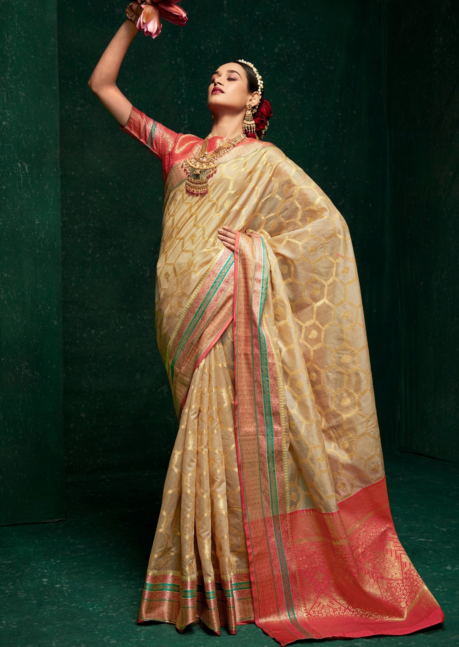 Woman in saree in front of a green wall