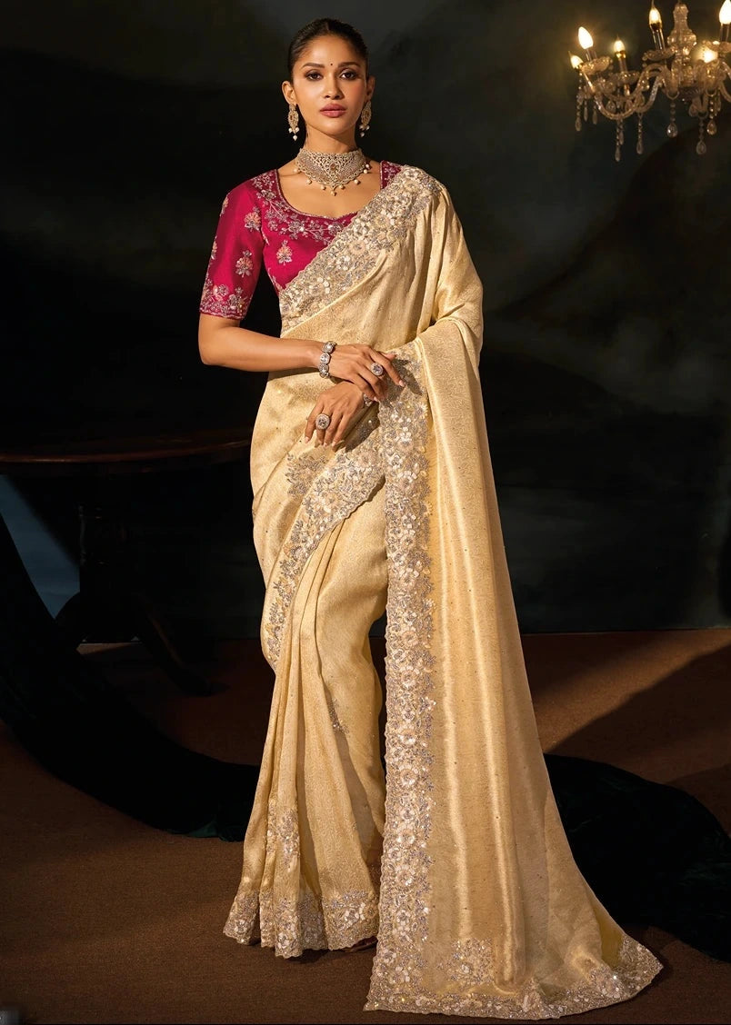 Full-length luxury bridal studio portrait of a bride wearing a premium cream Kanjivaram silk saree paired with a heavily hand-embroidered imperial red silk blouse and antique gold heritage jewelry.