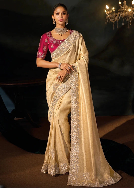 Full-length luxury bridal studio portrait of a bride wearing a premium cream Kanjivaram silk saree paired with a heavily hand-embroidered imperial red silk blouse and antique gold heritage jewelry.