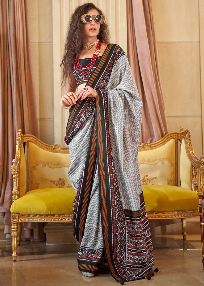 Designer grey and black patola silk saree with contrast border and woven motifs, perfect for 2026 summer wedding look, available for online shopping worldwide.