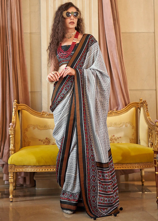 Designer grey and black patola silk saree with contrast border and woven motifs, perfect for 2026 summer wedding look, available for online shopping worldwide.