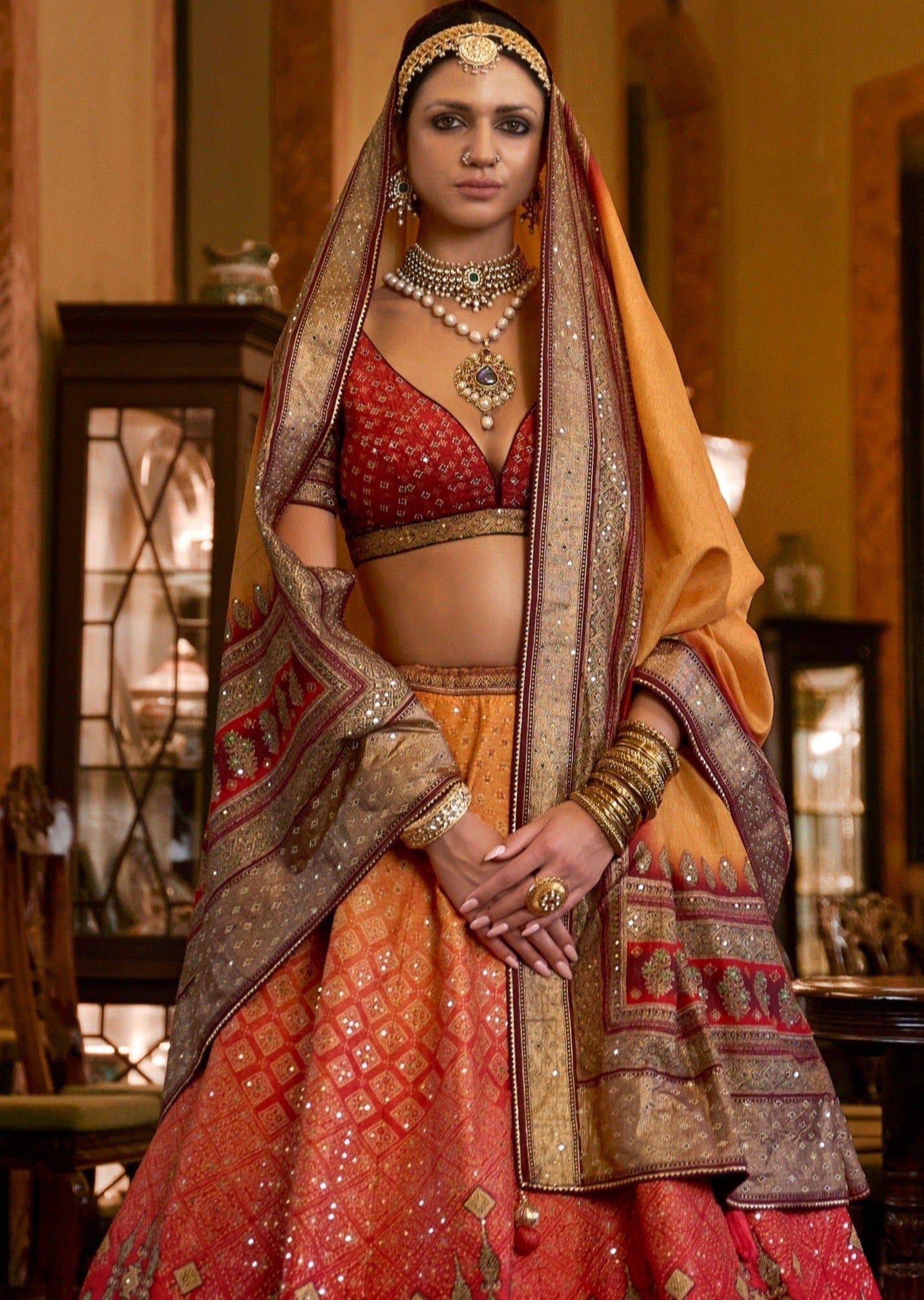 Woman in red yellow silk bridal lehenga choli with dupatta.