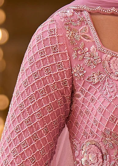 Close-up of a pink traditional embroidered anarkali sleeve with textured diamond-patterns and floral beadwork on the bodice.