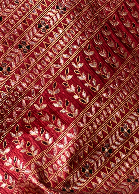 Close-up of gold zari work embroidery on red saree with meenakari; available for sale in norway.