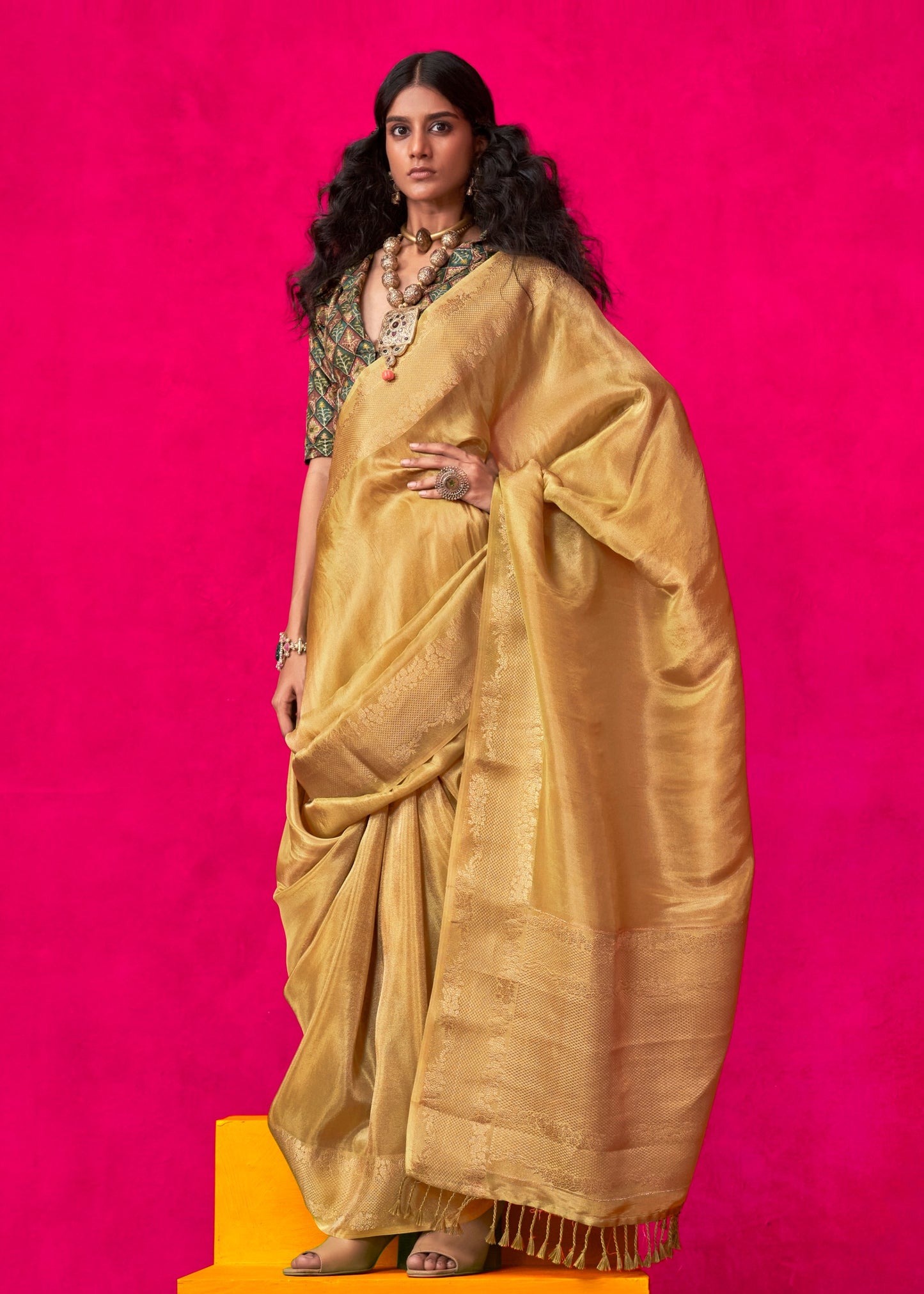 Golden yellow banarasi viscose tissue silk handloom saree showcasing intricate zari weaving and floral motifs.