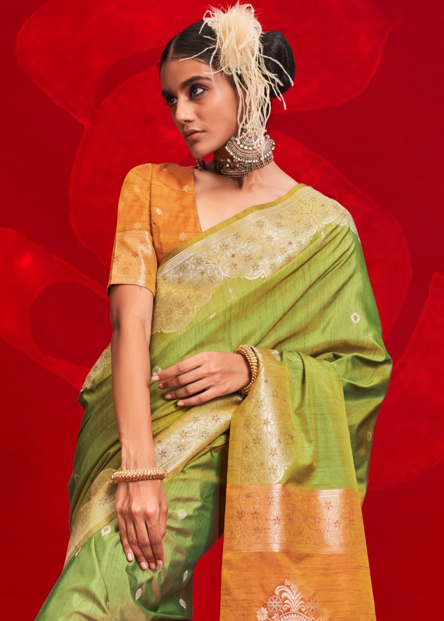 Model elegantly draped in a pure handloom tussar silk green saree paired with a bright orange blouse, perfect for festive occasions.