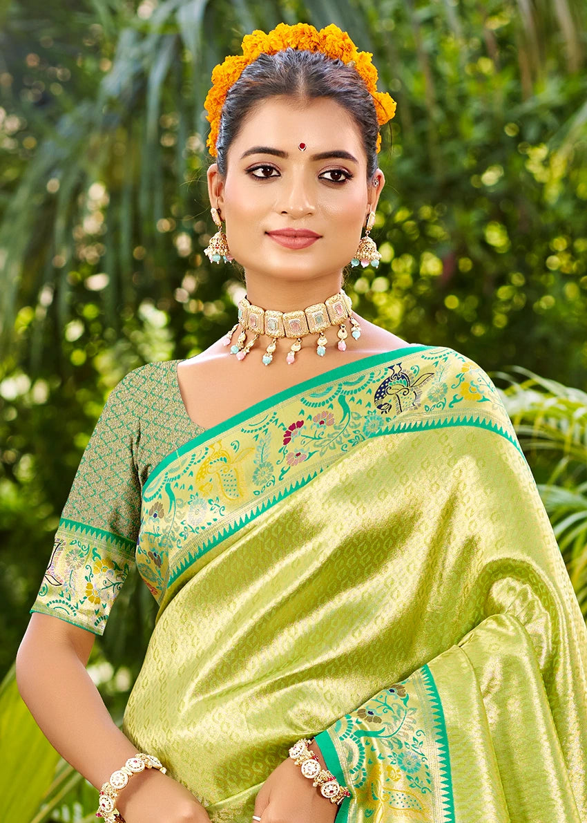 Woman wearing a green zari work saree in norway with floral embroidery and meenakari peacock motifs.