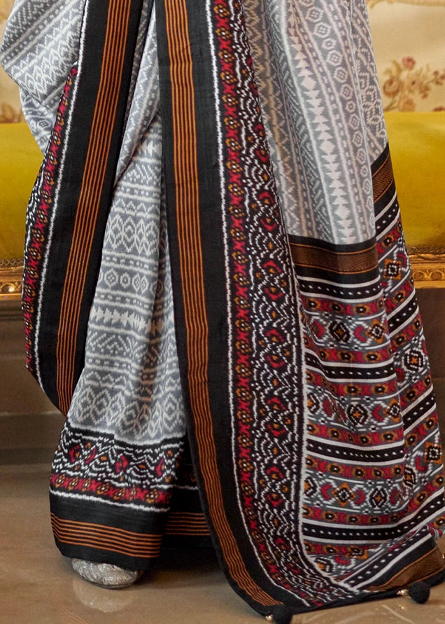 Grey silk saree pallu design with black border, lightweight drape, and heritage-inspired weave.