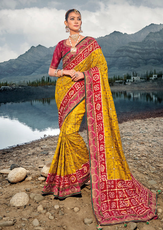 Hand embroidery kutch mirror work banarasi silk bandhej saree online in yellow and red color.