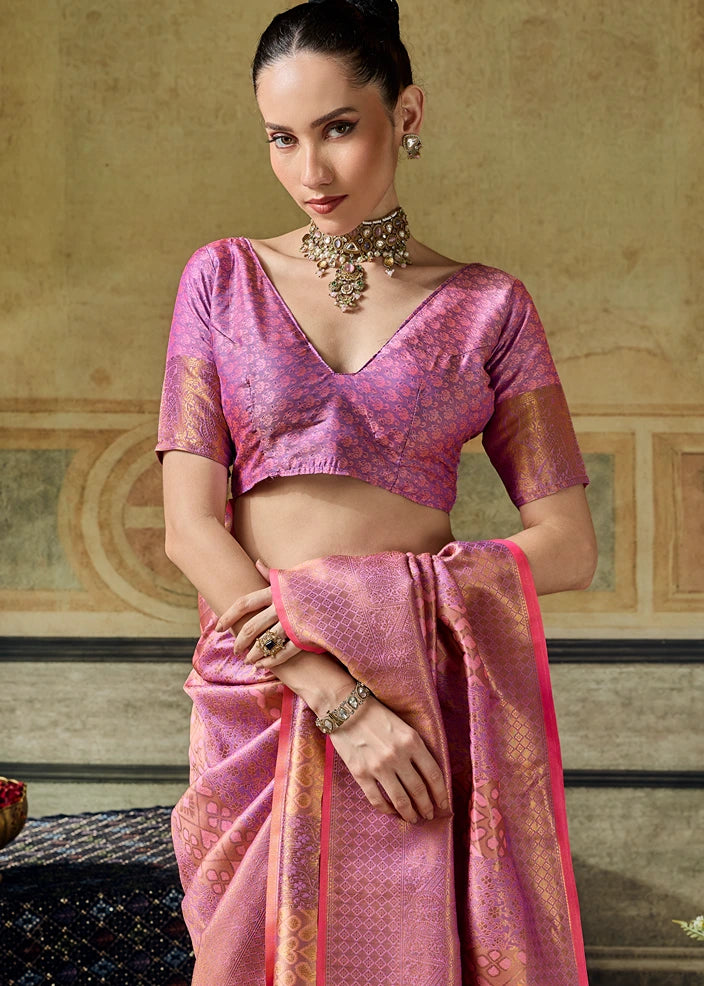 A woman models a light pink and gold patterned kanchipuram silk saree with a matching short-sleeve blouse, featuring patola ikkat design.