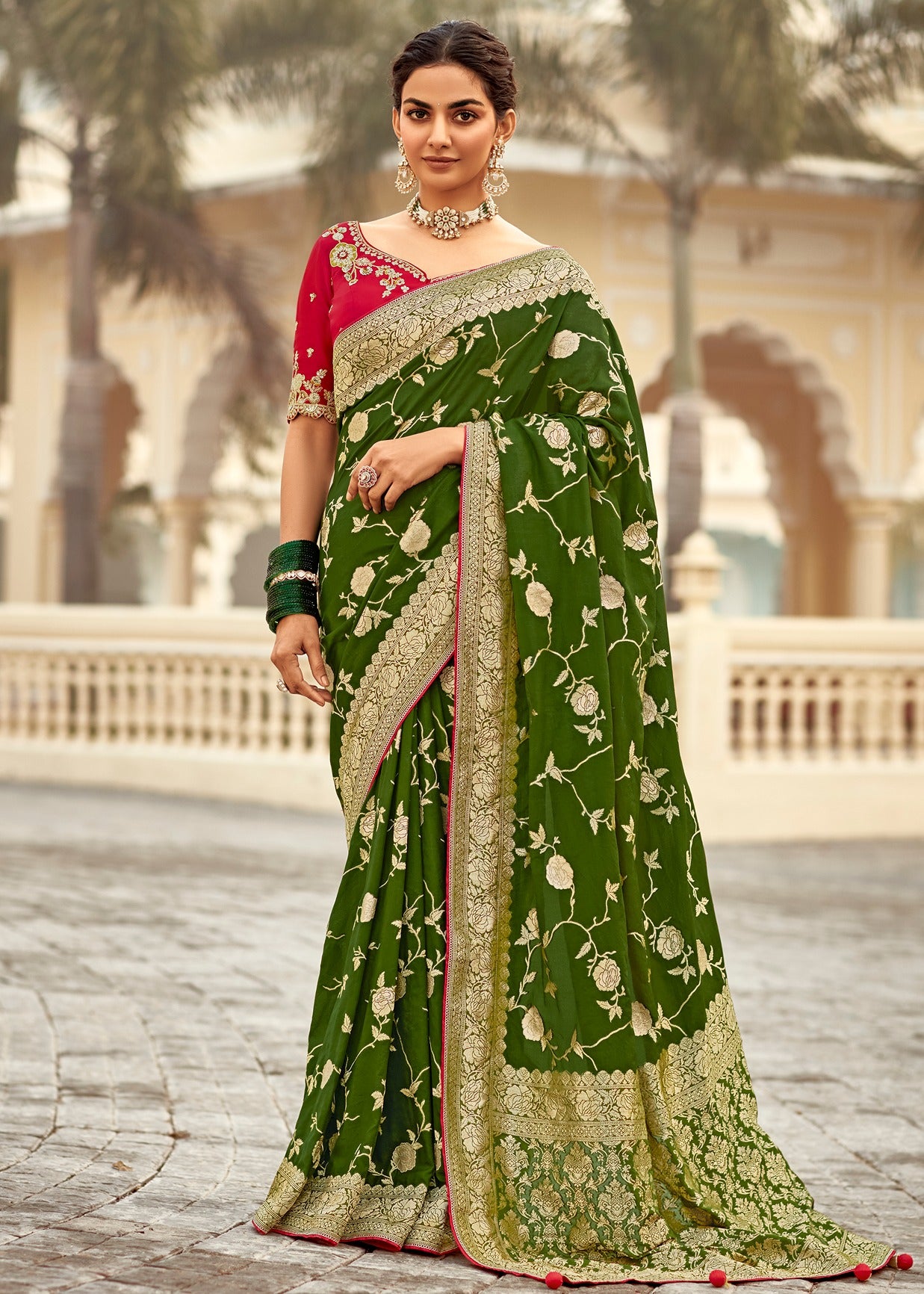 Luxury handloom silk saree in green colour with contrast red blouse featuring heavy embroidery work.