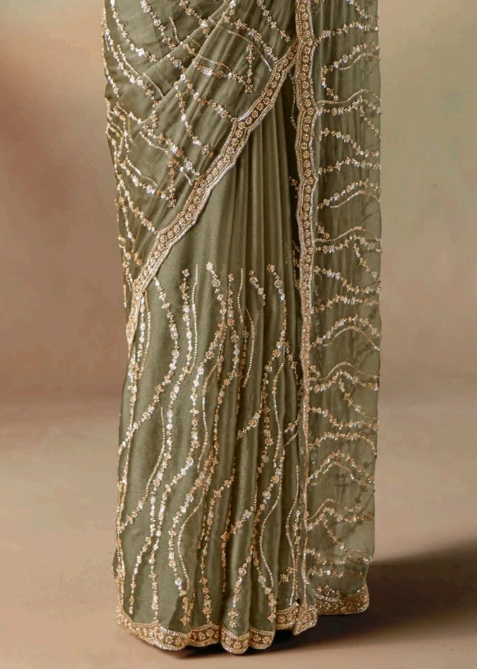 Olive green sheer organza tissue silk saree with shimmering sequins and beadwork hand embroidery for luxury bridal trousseau.