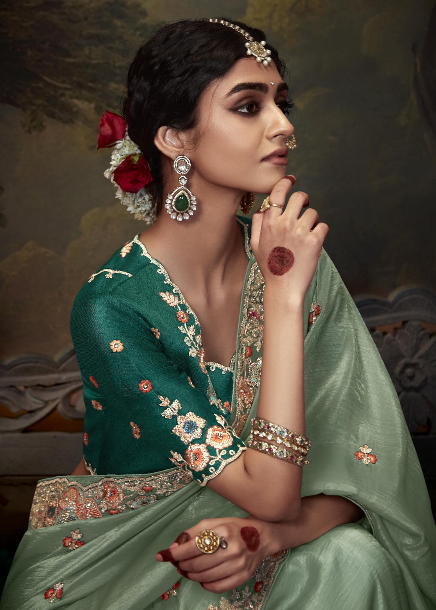 Luxurious pista green crushed tissue silk saree with detailed handwork embroidery and contrasting dark green embroidered blouse piece.