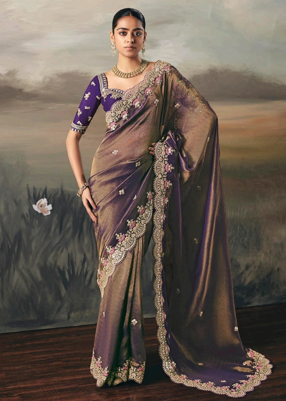 Metallic copper brown bridal saree with hand embroidered design on tissue silk paired with violet purple blouse.