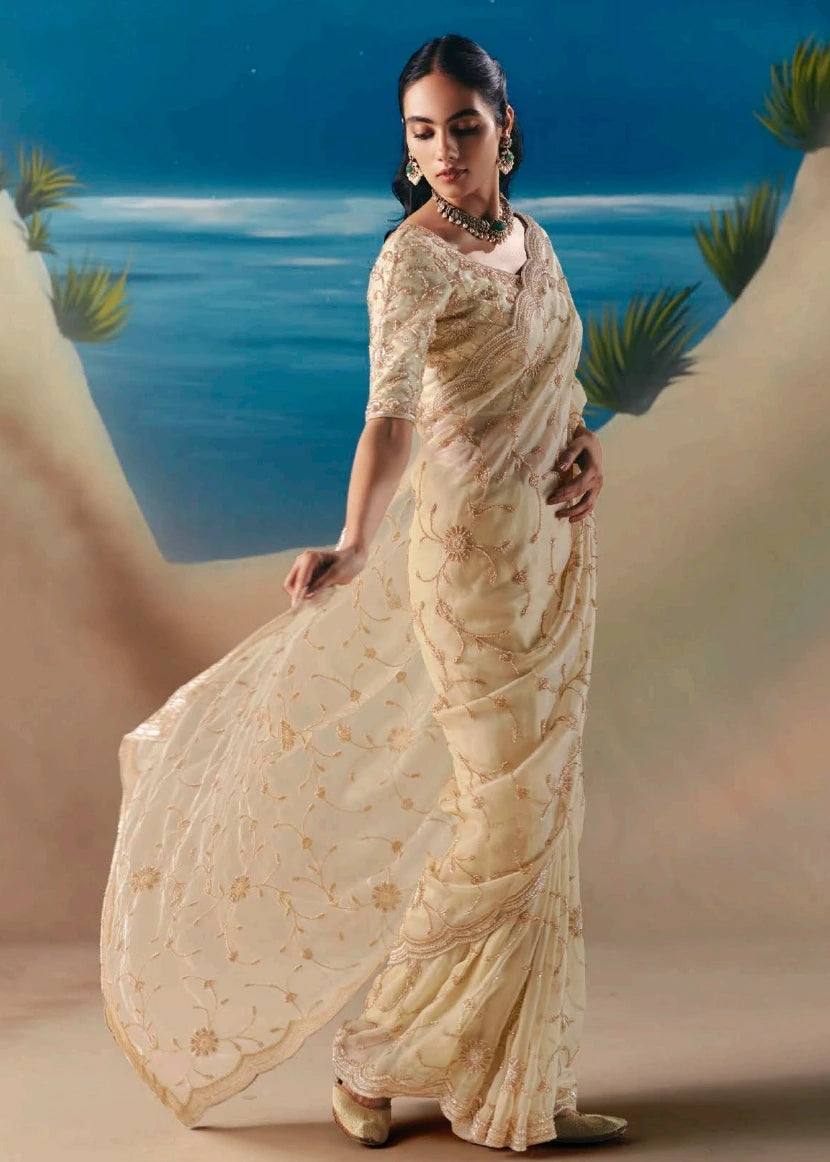Minimalist cream hand embroidered organza tissue bridal saree with subtle sequins accents and beadwork for contemporary bridal look.