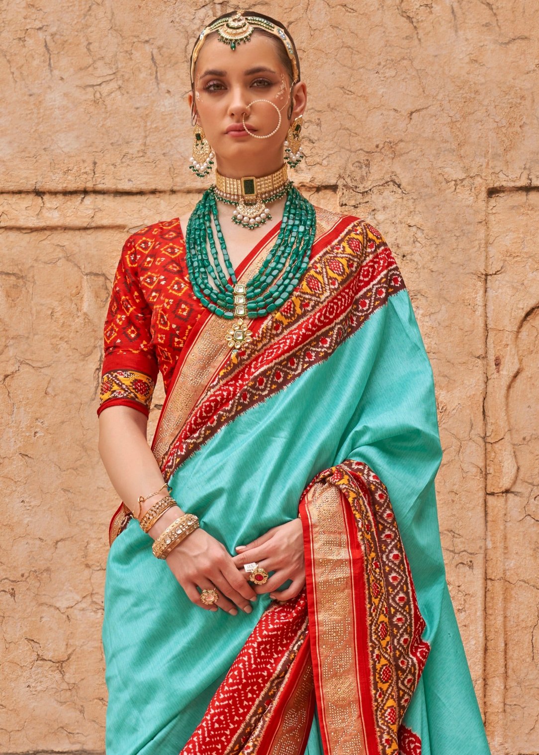 Ocean green patola silk saree with contrast red blouse in india online shopping for wedding and bridal wear.