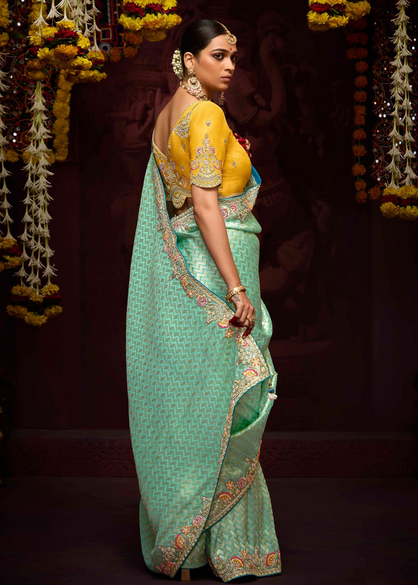 Ocean green banarasi silk saree and yellow blouse with intricate bridal handwork embroidery.