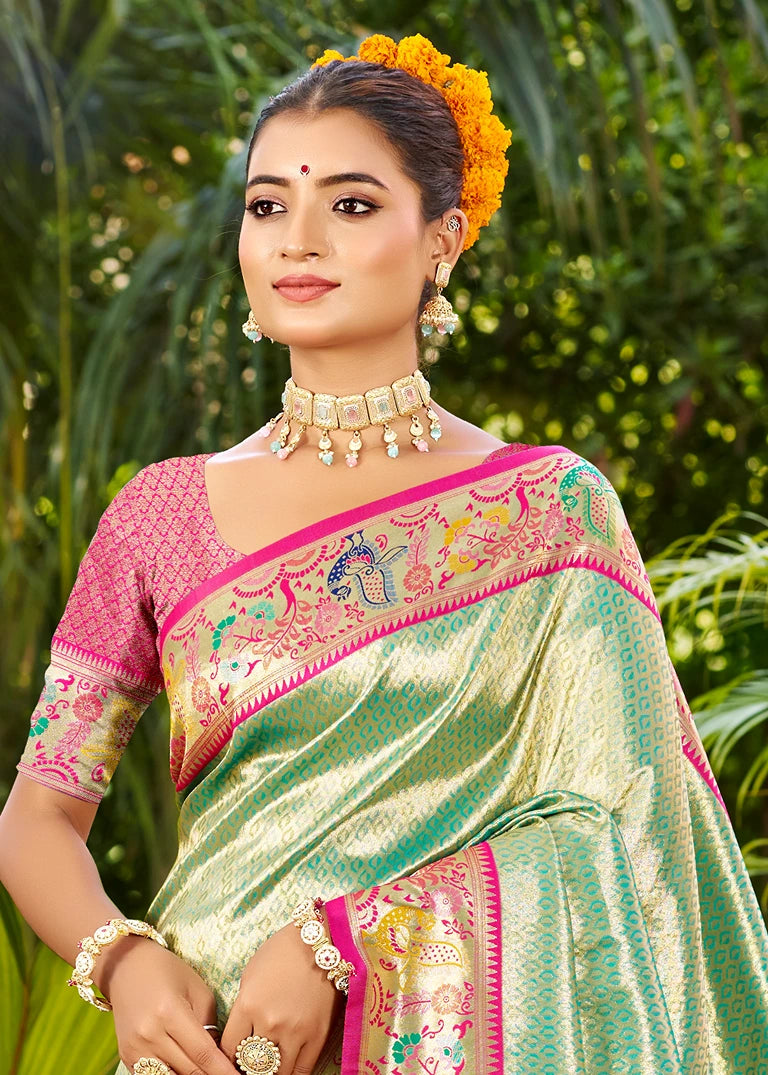 Woman wearing Ocean Green Paithani silk traditional saree at evening reception with gold meenakari jewelry, saree pallu showing handwoven zari peacocks and mor-popat border, fluid drape of pure mulberry silk, teal emerald shade, Indian handwoven luxury saree for sangeet and cocktail events in USA.