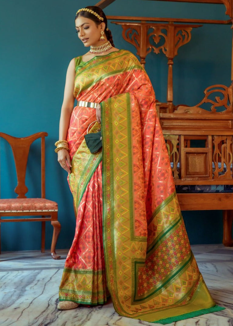 Luxury orange and green banarasi patola silk saree with geometrical and floral motifs showcasing rich weaving.