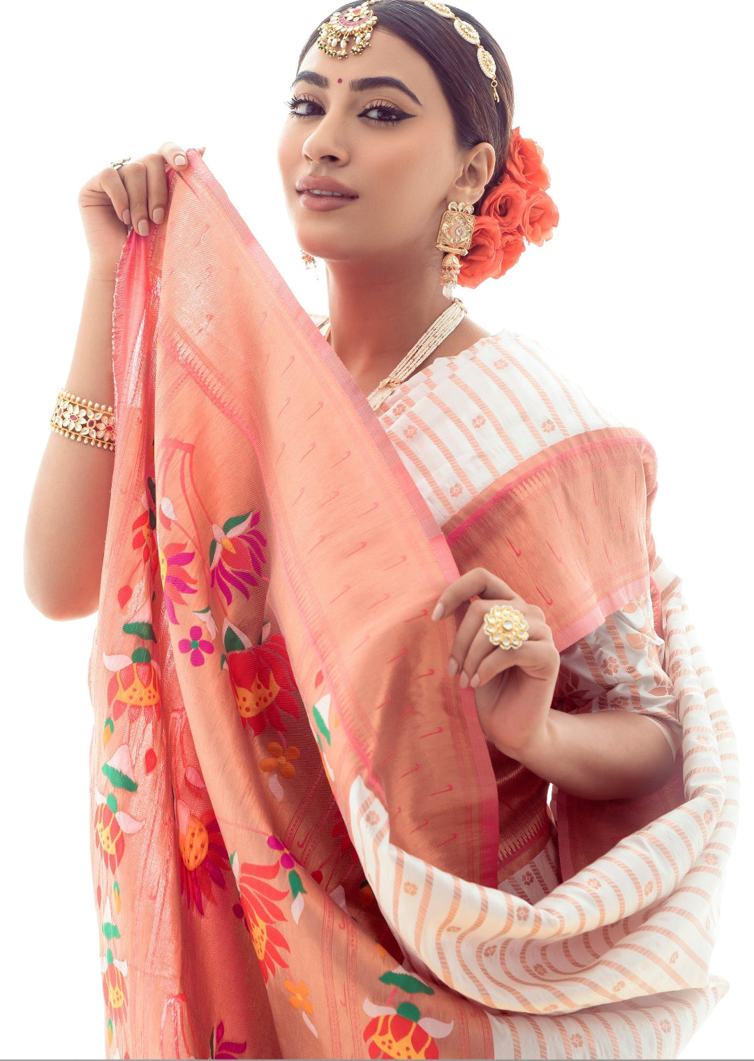 Woman wearing white paithani silk saree displays her saree pallu design having lotus weaving in meenakari designs.